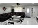 Open-concept living room featuring a large sofa, a decorative rug, and white tile flooring at 1748 Ragland Ave, Clearwater, FL 33765