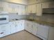 Kitchen with white cabinets, tile backsplash, and granite countertops at 2001 World Parkway Blvd # 49, Clearwater, FL 33763