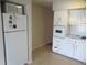 Kitchen with white appliances, cabinets and tile flooring with a microwave above the oven at 2001 World Parkway Blvd # 49, Clearwater, FL 33763