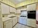 Efficient kitchen featuring white cabinets, tiled floor, and modern appliances at 2331 Finlandia Ln # 73, Clearwater, FL 33763