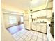 Well-lit kitchen featuring white cabinets, tiled floors, and a view of the living space at 2331 Finlandia Ln # 73, Clearwater, FL 33763