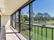 View of the balcony overlooking lush greenery with a black metal railing and sliding glass doors at 2700 Cove Cay Dr # 1-2D, Clearwater, FL 33760