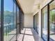 Wide angle view of an empty balcony with sliding doors and a view of the lawn and wooded area at 2700 Cove Cay Dr # 1-2D, Clearwater, FL 33760