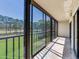 Spacious balcony with black metal railing providing panoramic views of the adjacent manicured lawn and trees at 2700 Cove Cay Dr # 1-2D, Clearwater, FL 33760