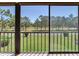 Screened-in balcony area with an expansive view of the surrounding landscape of trees and lawn at 2700 Cove Cay Dr # 1-2D, Clearwater, FL 33760