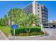 Exterior view of the condo building with palm trees and a manicured lawn in the foreground at 2700 Cove Cay Dr # 1-2D, Clearwater, FL 33760