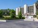 Exterior shot of the building, manicured greenery and parking awnings visible in the front at 2700 Cove Cay Dr # 1-2D, Clearwater, FL 33760
