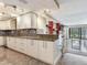 Kitchen featuring custom cabinets, stainless appliances, tile backsplash, and granite countertops at 2700 Cove Cay Dr # 1-2D, Clearwater, FL 33760