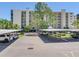 Wide shot showing the parking lot and multiple vehicles covered by awnings, with the building behind at 2700 Cove Cay Dr # 1-2D, Clearwater, FL 33760