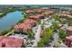 Aerial view showcases a waterfront community with lush landscaping, mature trees, tennis courts and a pool at 2739 Via Capri # 1024, Clearwater, FL 33764