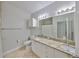 Bright bathroom with granite countertops, double sinks, and tiled floor exudes a clean, modern aesthetic at 2739 Via Capri # 1024, Clearwater, FL 33764