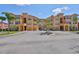 Multi-story building with garages, manicured landscaping, and neutral paint, perfect for community living at 2739 Via Capri # 1024, Clearwater, FL 33764