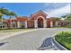 Elegant community clubhouse featuring a striking red exterior, arched entrance, and meticulous landscaping at 2739 Via Capri # 1024, Clearwater, FL 33764