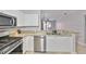 Kitchen featuring stainless steel dishwasher and appliances and white cabinets and granite counter tops at 2739 Via Capri # 1024, Clearwater, FL 33764