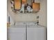 Functional laundry room featuring a washer, dryer, and storage shelf, simplifying chores at 2739 Via Capri # 1024, Clearwater, FL 33764