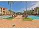 Community pool surrounded by lounge chairs and palm trees offers a resort-like relaxation and recreation at 2739 Via Capri # 1024, Clearwater, FL 33764