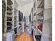 Organized walk-in closet with shelves, rods, and hardwood floors, provides ample storage space at 2739 Via Capri # 1024, Clearwater, FL 33764