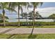 Picturesque water view from the community walking path, enhanced by palm trees and manicured landscaping at 2739 Via Capri # 1024, Clearwater, FL 33764