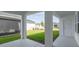 Covered patio looking out to backyard with lawn and a view of neighboring homes at 28776 Rambutan Dr, Wesley Chapel, FL 33543