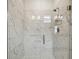 Modern bathroom shower featuring elegant marble tile, glass door, and sleek fixtures at 28776 Rambutan Dr, Wesley Chapel, FL 33543