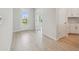 Bright entryway with views into other rooms; light hardwood flooring throughout the home at 28776 Rambutan Dr, Wesley Chapel, FL 33543