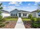 Charming single-story home with a blue accent and beautifully landscaped front yard at 28776 Rambutan Dr, Wesley Chapel, FL 33543