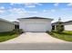 A single story home with a well maintained lawn and a two car garage at 28776 Rambutan Dr, Wesley Chapel, FL 33543