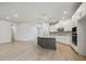 Spacious kitchen with a large island, white cabinets, and stainless steel appliances, hardwood flooring at 28776 Rambutan Dr, Wesley Chapel, FL 33543