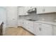 Bright kitchen featuring white cabinets, modern countertops and stainless steel appliances with wood flooring at 28776 Rambutan Dr, Wesley Chapel, FL 33543