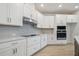 Bright kitchen featuring white cabinets, stainless steel appliances and wood flooring at 28776 Rambutan Dr, Wesley Chapel, FL 33543