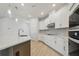 Bright kitchen with white cabinets, quartz countertops, stainless steel appliances, and wood flooring at 28776 Rambutan Dr, Wesley Chapel, FL 33543