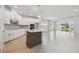 Open kitchen with large island, white cabinets, modern appliances, and light hardwood flooring at 28776 Rambutan Dr, Wesley Chapel, FL 33543