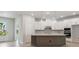 Open kitchen with large island, white cabinets, modern appliances, and light hardwood flooring at 28776 Rambutan Dr, Wesley Chapel, FL 33543