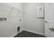 Laundry room with sleek black tiled floor and storage at 28776 Rambutan Dr, Wesley Chapel, FL 33543