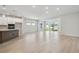 Open concept living room and kitchen featuring light wood floors, neutral paint and access to a patio at 28776 Rambutan Dr, Wesley Chapel, FL 33543
