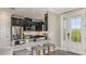 Modern kitchen with stainless steel appliances, dark cabinets, a breakfast bar with seating, and lots of natural light at 29516 Zupetta Ln, Wesley Chapel, FL 33545