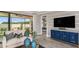 Comfortable living room featuring a cozy couch, a blue accent cabinet with marble top, and sliding glass doors to screened patio at 29516 Zupetta Ln, Wesley Chapel, FL 33545