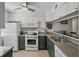 Well-lit kitchen with a ceiling fan, white appliances, and granite countertops at 3001 58Th S Ave # 509, St Petersburg, FL 33712
