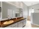 Bathroom featuring double sinks, a large mirror, and walk-in shower behind glass door at 3329 Cypress Landing Dr, Valrico, FL 33596