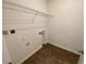 A functional laundry room includes washer/dryer hookups, ample space, and shelving for storage at 35003 Daisy Meadow Loop, Zephyrhills, FL 33541