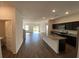 Spacious living room is complemented by luxury vinyl flooring and a view into the modern kitchen at 35003 Daisy Meadow Loop, Zephyrhills, FL 33541