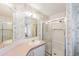 Well-lit bathroom featuring a shower, vanity, and mirror at 37422 Neukom Ave, Zephyrhills, FL 33541