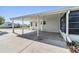 Covered carport with concrete floor and screened in porch area at 37422 Neukom Ave, Zephyrhills, FL 33541