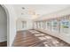 Sun-filled living room boasting hardwood floors and multiple windows for ample natural light at 37422 Neukom Ave, Zephyrhills, FL 33541