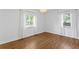 Bright bedroom featuring hardwood floors, white walls, and dual windows at 432 39Th Ne Ave, St Petersburg, FL 33703