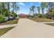 Wide driveway leading to a well-maintained single-story home, surrounded by lush trees and manicured lawn at 4344 Eldron Ave, North Port, FL 34286