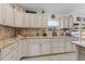 Bright kitchen features cream-colored cabinets, granite countertops, and diamond tile backsplash at 4344 Eldron Ave, North Port, FL 34286