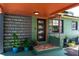 Close up of a unique covered front porch with decorative plants and a modern black front door at 4730 15Th N Ave, St Petersburg, FL 33713