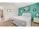 Well-lit bedroom with green accent wall, hardwood floors, and white wicker furniture at 5247 81St N St # 4, St Petersburg, FL 33709