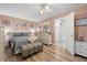 Bedroom featuring a queen-sized bed, ensuite bathroom, wood floors, and pink walls at 5247 81St N St # 4, St Petersburg, FL 33709